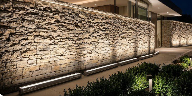 Hiệu ứng ánh sáng mịn từ đèn LED Wall Washer chuyên dụng hắt lên bức tường đá mặt tiền biệt thự sang trọng được thi công bởi Bảo Châu Ad.